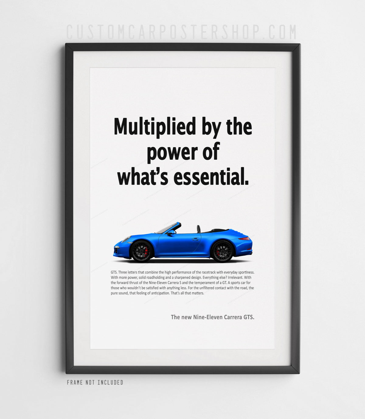 Blue Porsche 911 Carrera GTS Cabriolet (991.1), roof down, in side profile on the ‘Power of What’s Essential’ retro print ad, shown in a black frame mock-up.